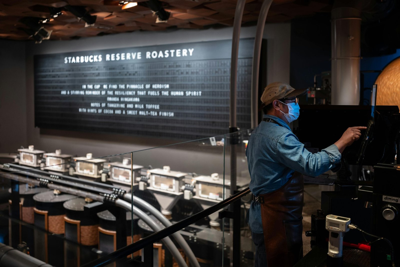 A barista operates machinery at Starbucks Reserve Roastery, showcasing the coffee production process.