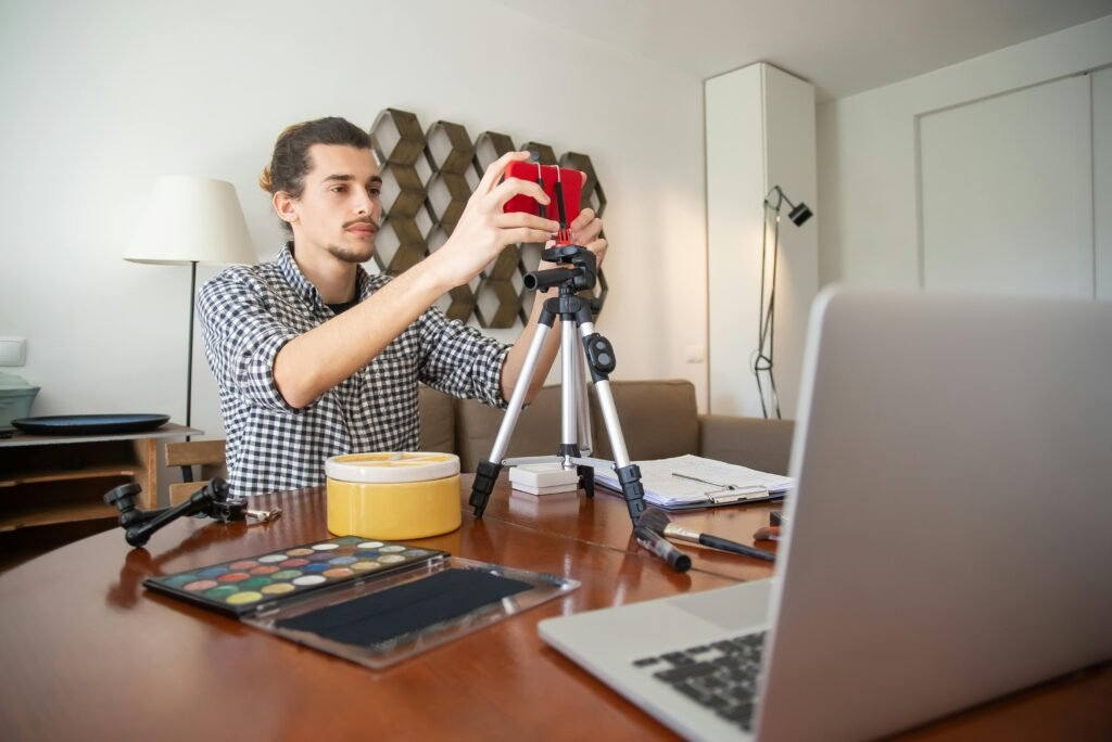 pexels-photo-7514814-7514814 A male vlogger adjusts his camera on a tripod, preparing for a video shoot in a stylish home studio.