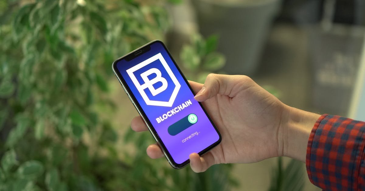 Close-up of a smartphone showing a blockchain app screen held by a hand.